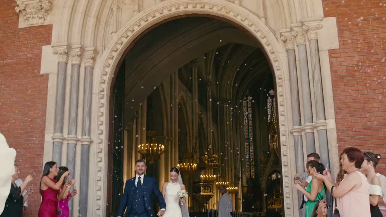 A bride and groom walking out of their ceremony as guests cheer